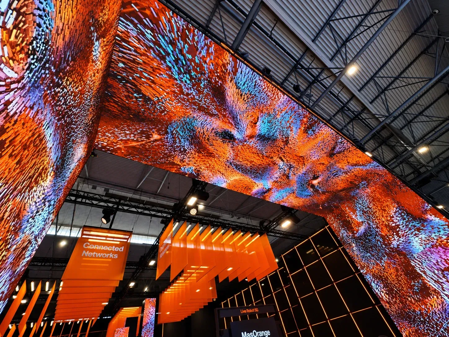 Upward view of the Orange MWC25 LED gateway and flowing data artwork